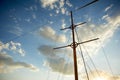 The wooden mast of an old ship on the background of blue sky.Going out to sea and adventures Royalty Free Stock Photo