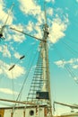 Wooden mast and ropes of sailboat, View of the ship`s masts from below, Detailed rigging without sails against blue sky. Royalty Free Stock Photo