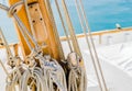 Yachting, rigging nautical ropes tied on wood mast on deck of classical sailing boat Royalty Free Stock Photo