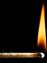 Wooden match burns with an orange flame against a black Royalty Free Stock Photo