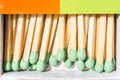 Wooden matches with a green sulfur head, lie in a box, macro abstraction subject