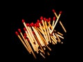 Wooden matches with red sulfur heads on a black background