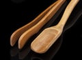 A wooden measuring spoon, tea tongs on a black background, a Chinese tea party Royalty Free Stock Photo