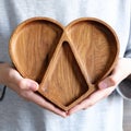 Wooden menagerie in the shape of a heart in women& x27;s hands