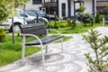 Wooden and metal bench in a beautiful green courtyard with many plants in a gated community. A place for a relaxing break