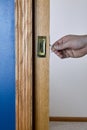 Pocket door by blue wall being unlocked and opened