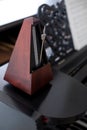 Wooden metronome on an old black piano