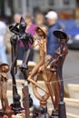 Wooden mini sculptures put up for sale during street fair, blurred people on a background