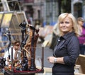 Wooden mini sculptures put up for sale during street fair, woman artist standing near to sell them