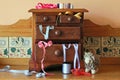 Wooden miniature chest of drawers with sewing utensils surrounding it