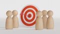 Wooden miniature figures standing with dartboard and arrow for setup business objective target and goal concept.