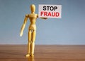 Wooden model of a man holding a tablet saying `stop fraud Royalty Free Stock Photo