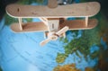 Wooden model vintage airplane is on the Earth globe