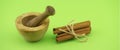 Wooden mortar and pestle near cinnamon sticks bundle Royalty Free Stock Photo