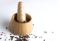 Wooden mortar and pestle with peppercorn mix on white table Royalty Free Stock Photo