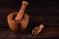 wooden mortar with small wooden spoon for spices, pepper, low key, rustic Royalty Free Stock Photo