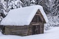 Wooden mountain shed, against the backdrop of snowy forest. Royalty Free Stock Photo