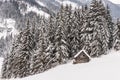 Wooden mountain shed, against the backdrop of snowy mountains and trees. Royalty Free Stock Photo