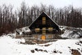 Wooden mountain snow covered cottage with stone foundation Royalty Free Stock Photo