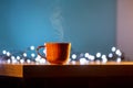 Wooden mug with coffee. Steam comes from the cup from hot coffee, chocolate, tea. Christmas lights in the background. Christmas is Royalty Free Stock Photo