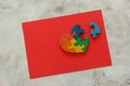 Wooden multicolor puzzle in the form of heart with disconnected piece on a red sheet on gray background. Concept