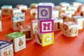 Wooden multicolored blocks with letters on orange background. Education for preschooler, reading, alphabet. Back to school concept Royalty Free Stock Photo