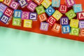 Wooden multicolored blocks with letters on orange background. Education for preschooler, reading, alphabet. Back to school concept Royalty Free Stock Photo