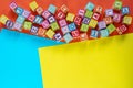 Wooden multicolored blocks with letters on orange background. Education for preschooler, reading, alphabet. Back to school concept Royalty Free Stock Photo