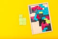 Wooden multicolored puzzle on yellow background. Flat lay