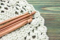 Wooden natural bamboo crochet hooks on the crochet doily and on the table. Creative work place for homemade crafts.