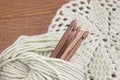 Wooden natural bamboo crochet hooks, doily and yarn ball on the table. Creative work place for homemade crafts. Top view.