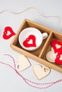 Wooden red hearts decorations stuff for gifts twine in cardboard holder light background. Eco set for Valentine\'s Day Royalty Free Stock Photo