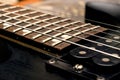 Wooden neck of a black guitar close up Royalty Free Stock Photo