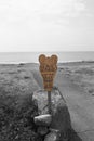 Wooden no littering sign in the shape of a foot. Ecological clean beach environment concept