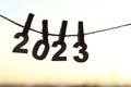 Wooden number hang on rope attached with clothes peg pins over orange morning sky sunrise and blurred city bokeh light background