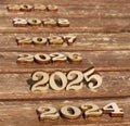 wooden number 2025 with 2024 and 2026 2027 2028 2029 in the sun on a sunny day