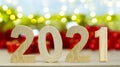 Wooden number of Two thousand twenty one and blur red gift box and Christmas bokeh background