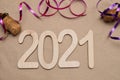 Light wooden 2021 numbers lie randomly on craft paper with champagne corks, packing tape and muzlet Royalty Free Stock Photo