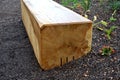 A wooden oak prism serves as a bench in the garden. for better drying of the wood, grooves are milled in the lower part, which pre Royalty Free Stock Photo