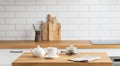 Wooden oak table with a cup of tea and a kettle in front of the kitchen with a white brick background Royalty Free Stock Photo