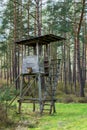 A wooden observation or hunting tower in the middle of a forest