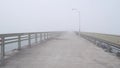 Wooden Ocean Beach pier in fog, misty calm boardwalk in haze, California coast.