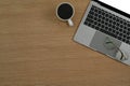 Wooden office desk with laptop computer, coffee cup and eyeglasses. Top view with copy space Royalty Free Stock Photo