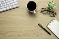 Wooden office desk table with keyboard, notebook and coffee cup with equipment other office supplies. Royalty Free Stock Photo