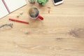 For design wooden office desk table with notebook, glasses, plant, red cup of coffee and other office supplies. Top view with copy