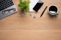 Wooden office desk table with smartphone with blank mock up screen, laptop computer, cup of black coffee and supplies. Top view Royalty Free Stock Photo