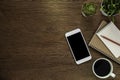 Wooden office desk table with smartphone, notebook and coffee cup with equipment office supplies.