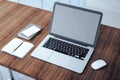 Wooden office desktop with empty laptop screen