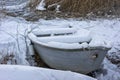 Wooden old boat on the shore in winter. Vintage snowy white postcard background. Royalty Free Stock Photo