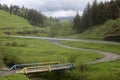 Wooden old bridge over a creek in the valley of a mountain road Royalty Free Stock Photo